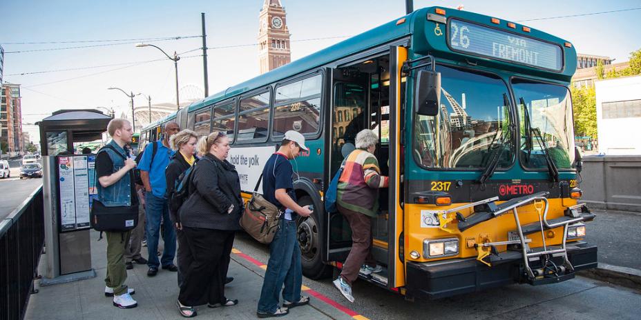 Group of people getting in on transit bus. 