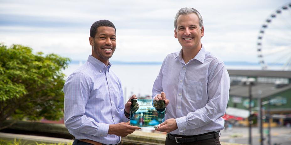 Two people holding an award